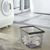 The elegant black medium Tower Laundry Basket is shown on the floor of the laundry room.